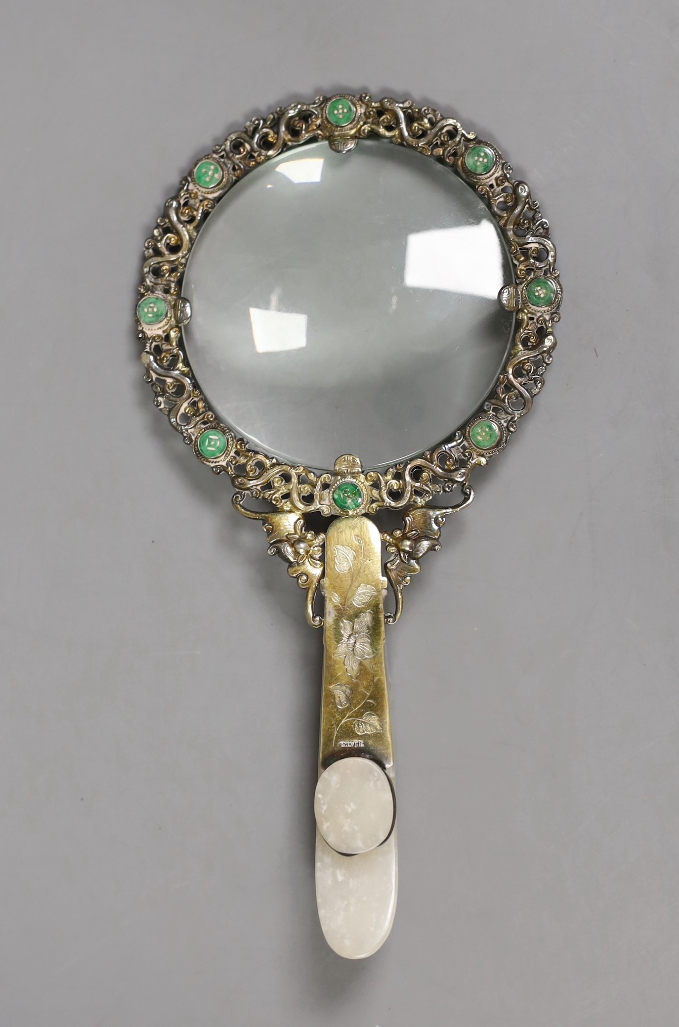 An Eastern white metal ‘SILVER’ marked magnifying glass with carved jade belt hook handle, total length 20cm